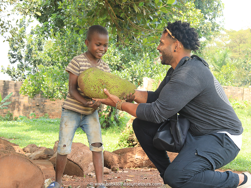 Brenden Durell and with a jackfruit and a kid in Kampala